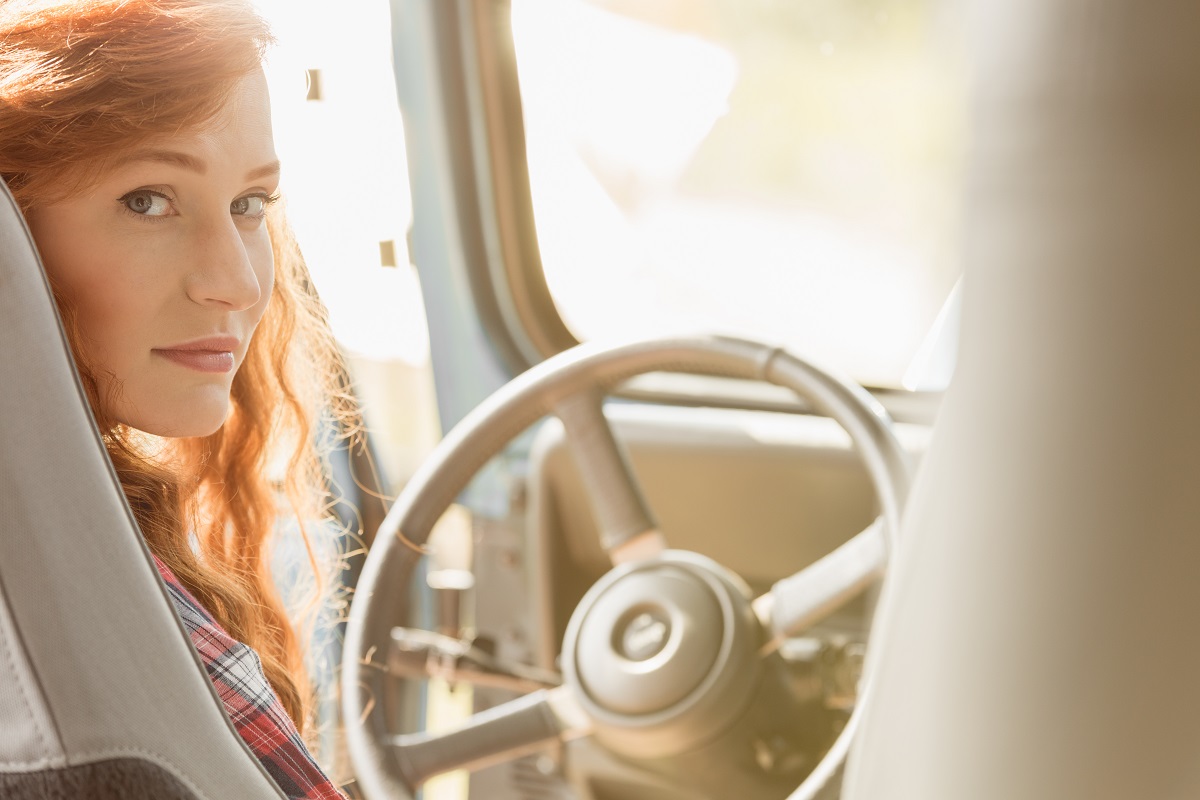 Young and beautiful ginger woman driving car
