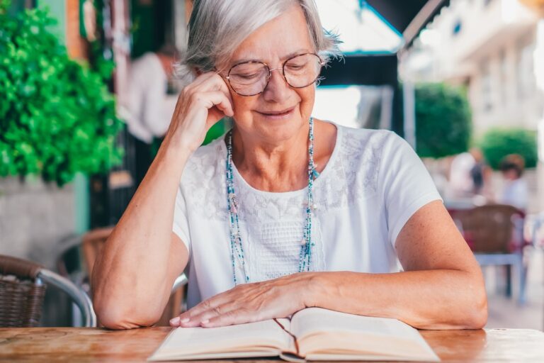 Eine ältere Frau liest ein Buch, um ihre geistigen Leistungen zu verbessern