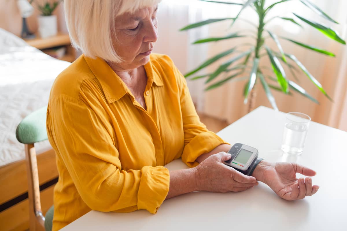 Der Senior benutzt ein Herzfrequenzmessgerät, um seinen Puls zu kontrollieren, weil er zu hoch ist