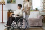 Opiekunka pcha wózek inwalidzki z seniorem